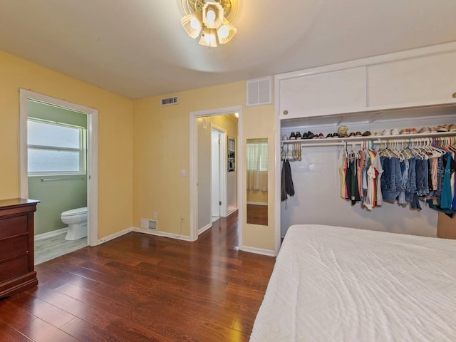 bedroom with connected bathroom, dark wood-type flooring, and a closet