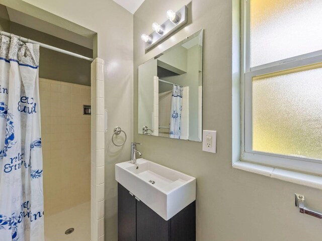 bathroom featuring curtained shower, vanity, and a wealth of natural light