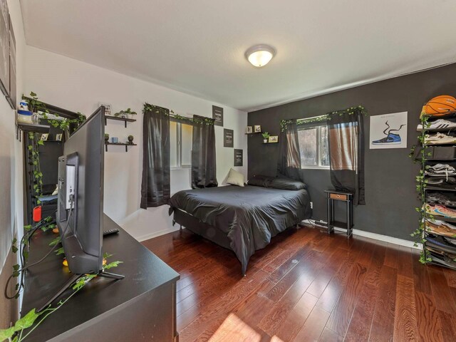 bedroom with dark wood-type flooring