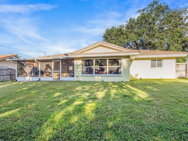 back of house featuring a sunroom and a yard