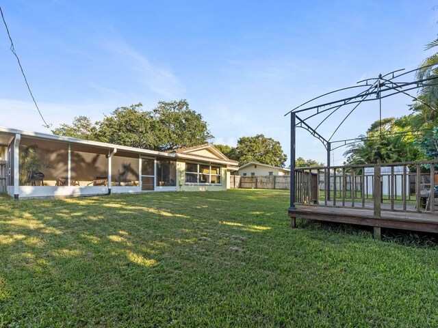 view of yard with a sunroom and a wooden deck