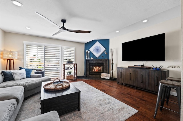 living room with a premium fireplace, ceiling fan, and dark hardwood / wood-style floors