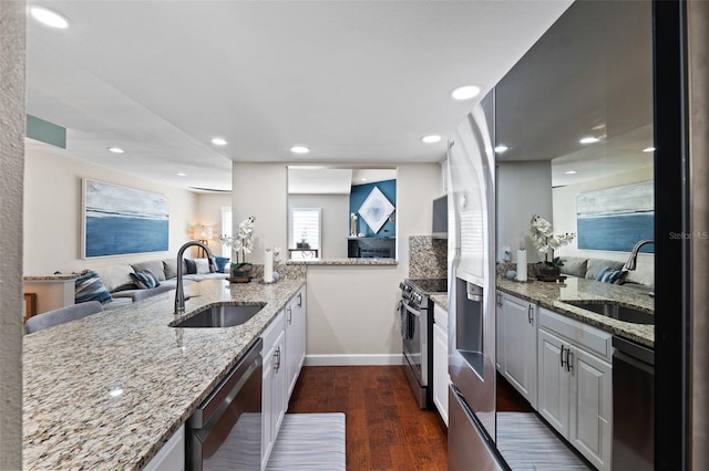 kitchen featuring appliances with stainless steel finishes, sink, dark hardwood / wood-style flooring, and white cabinetry