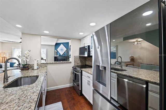 kitchen featuring light stone counters, dark hardwood / wood-style floors, sink, white cabinets, and stainless steel appliances