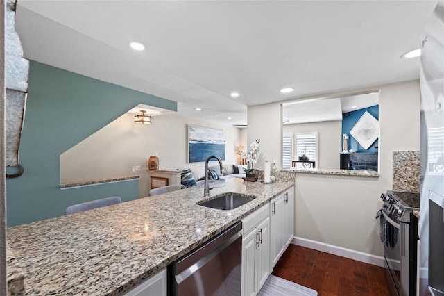 kitchen featuring white cabinets, light stone countertops, dark hardwood / wood-style flooring, stainless steel appliances, and sink