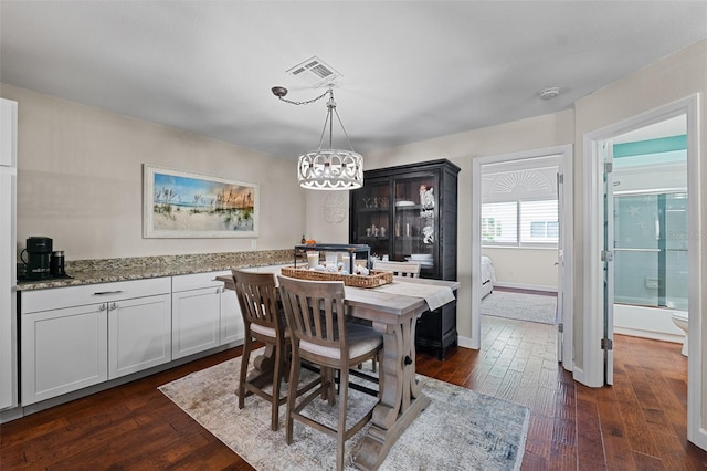 dining room with dark hardwood / wood-style floors and a chandelier