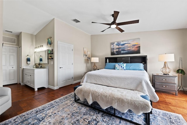 bedroom featuring vaulted ceiling, ceiling fan, ensuite bathroom, and dark hardwood / wood-style flooring