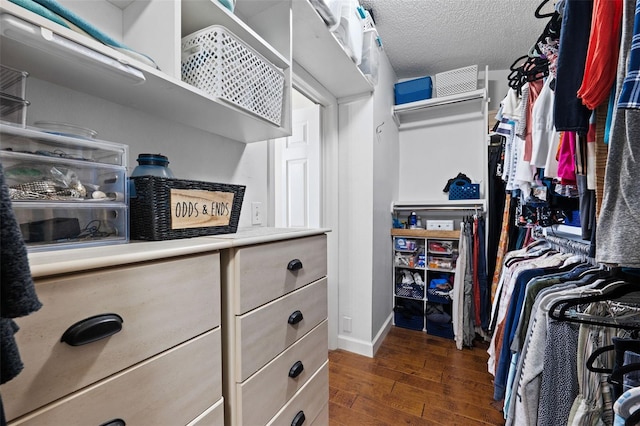 walk in closet with dark wood-type flooring