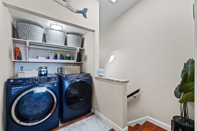 clothes washing area featuring hardwood / wood-style flooring and washing machine and dryer