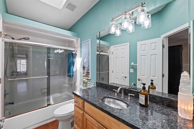 full bathroom featuring shower / bath combination with glass door, vanity, and toilet