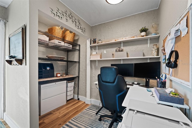 office with built in desk and light hardwood / wood-style flooring