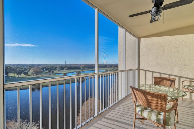 balcony featuring a water view and ceiling fan