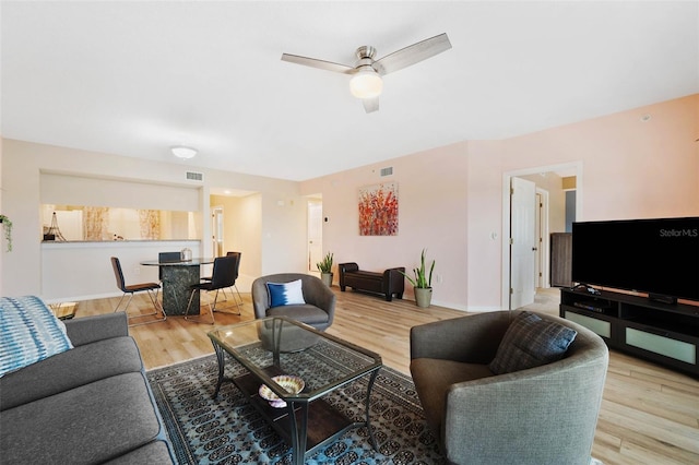 living room featuring hardwood / wood-style floors and ceiling fan