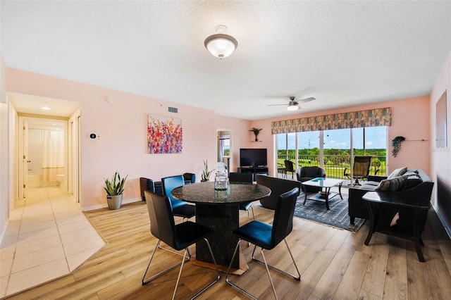 dining area featuring ceiling fan, a textured ceiling, and light wood-type flooring