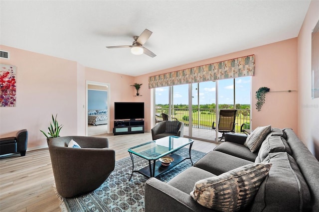 living room with light wood-type flooring and ceiling fan