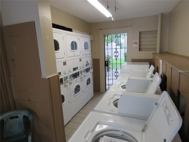 washroom with stacked washer and dryer, light tile patterned flooring, and washer and dryer