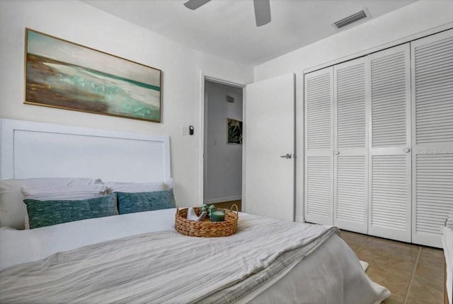 tiled bedroom with ceiling fan and a closet