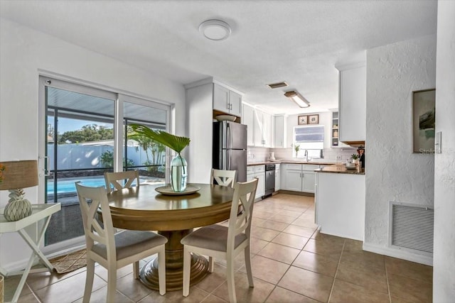 tiled dining area with a healthy amount of sunlight and sink