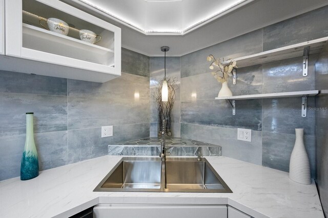 interior details featuring open shelves, light stone counters, and white cabinetry