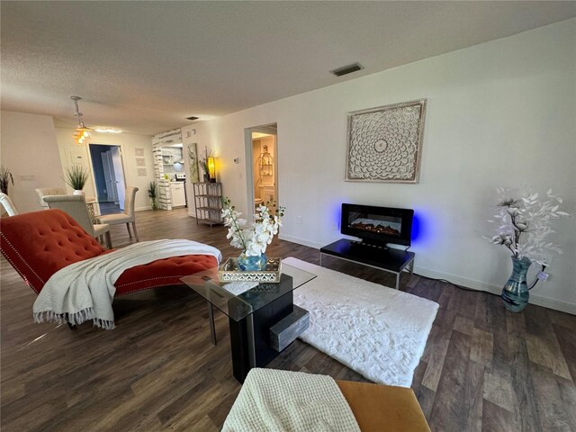 living room featuring a textured ceiling and dark wood-type flooring