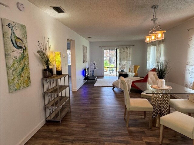 dining space featuring baseboards, a textured ceiling, visible vents, and dark wood-type flooring