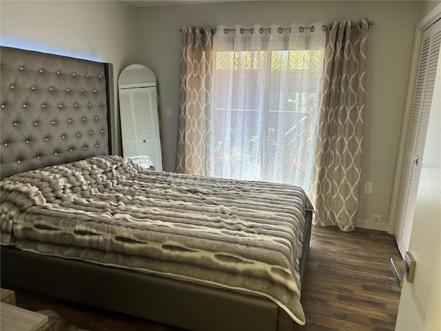 bedroom featuring dark wood-type flooring, a closet, and baseboards