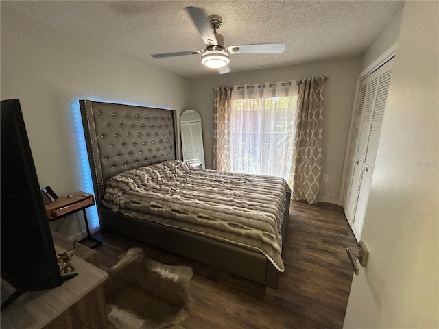 bedroom featuring a textured ceiling, a closet, dark wood-type flooring, and ceiling fan