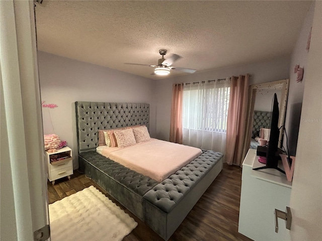 bedroom with ceiling fan, dark wood-type flooring, and a textured ceiling