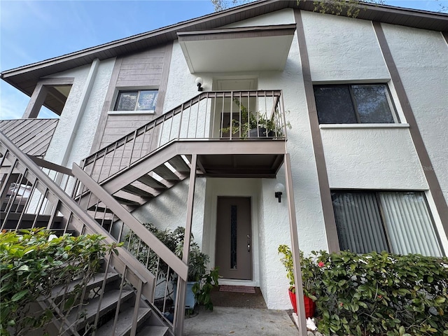 doorway to property featuring a balcony and stucco siding