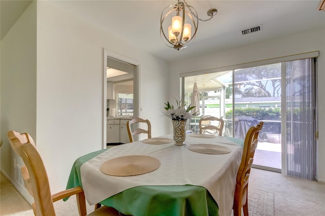 carpeted dining space featuring an inviting chandelier and a wealth of natural light