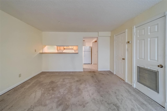 carpeted empty room with heating unit and a textured ceiling