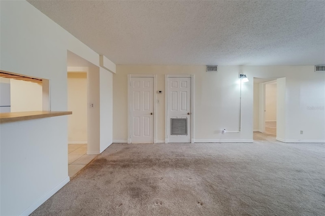 carpeted spare room featuring a textured ceiling