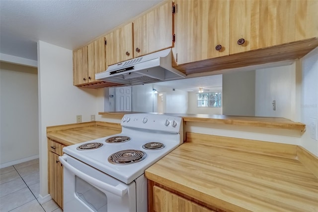 kitchen featuring light tile patterned floors, light brown cabinets, white range with electric stovetop, and a textured ceiling