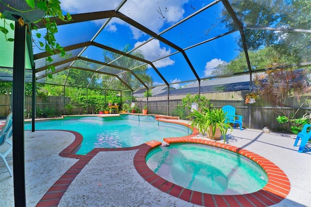 view of pool featuring glass enclosure, an in ground hot tub, and a patio