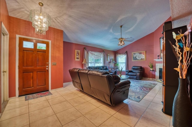 tiled living room with ceiling fan with notable chandelier, a textured ceiling, and lofted ceiling