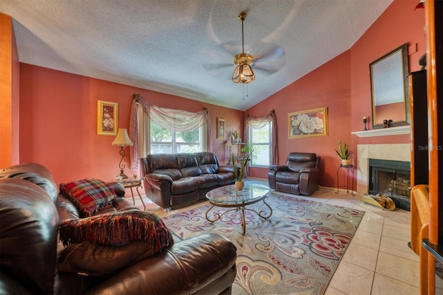 tiled living room with ceiling fan, lofted ceiling, and a textured ceiling