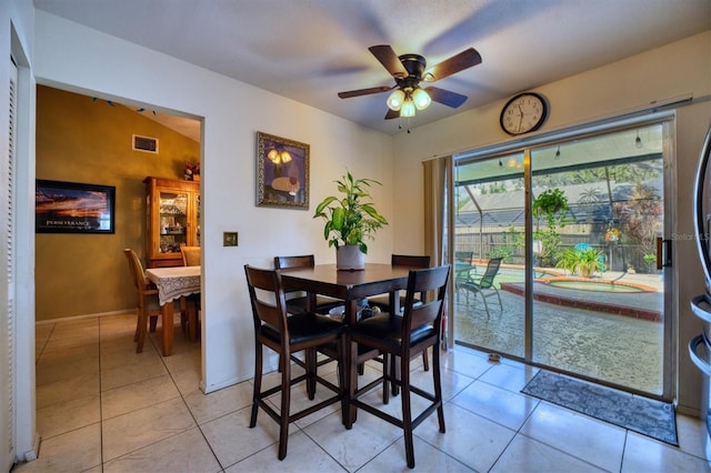 dining area with light tile patterned floors, vaulted ceiling, and ceiling fan