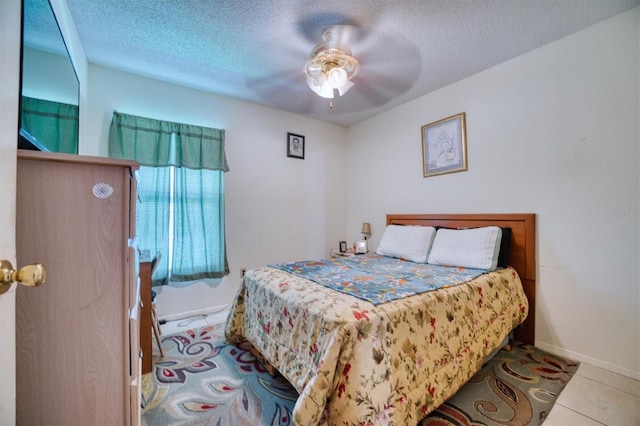 bedroom with light tile patterned floors, a textured ceiling, and ceiling fan