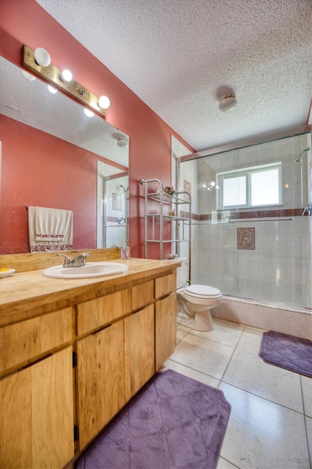 bathroom with tile patterned flooring, vanity, a textured ceiling, and a shower with shower door