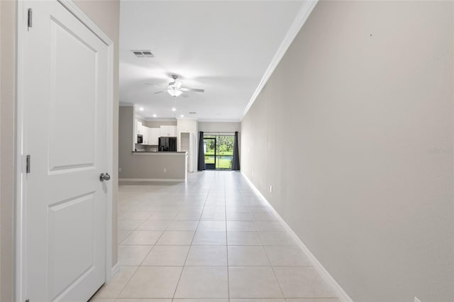 corridor featuring light tile patterned flooring and ornamental molding