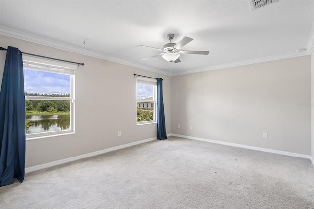 carpeted spare room featuring ceiling fan, crown molding, and a water view