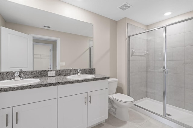 bathroom featuring tile patterned flooring, an enclosed shower, vanity, and toilet