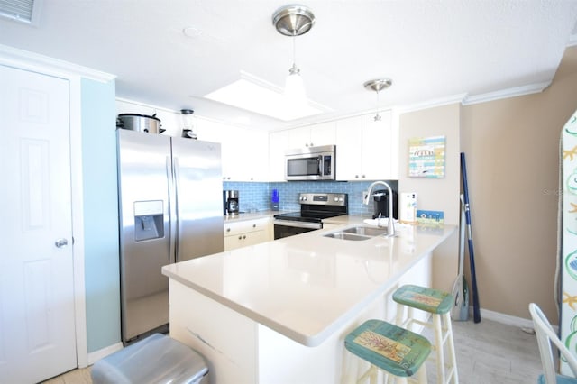 kitchen featuring white cabinets, sink, hanging light fixtures, kitchen peninsula, and stainless steel appliances