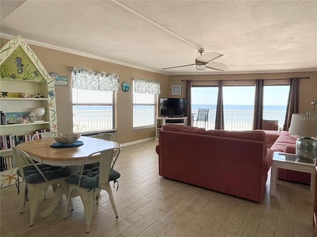 living room with hardwood / wood-style flooring, ceiling fan, crown molding, and a wealth of natural light