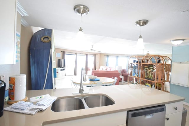 kitchen with sink, white cabinets, stainless steel dishwasher, and decorative light fixtures