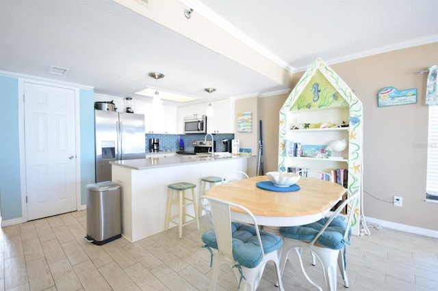 dining space with light wood-type flooring and ornamental molding