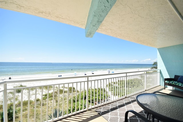 balcony with a water view and a beach view