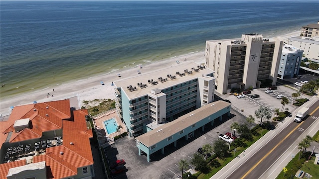 birds eye view of property with a water view and a beach view