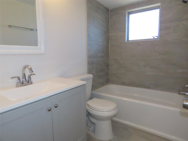 full bathroom with tiled shower / bath, vanity, and toilet