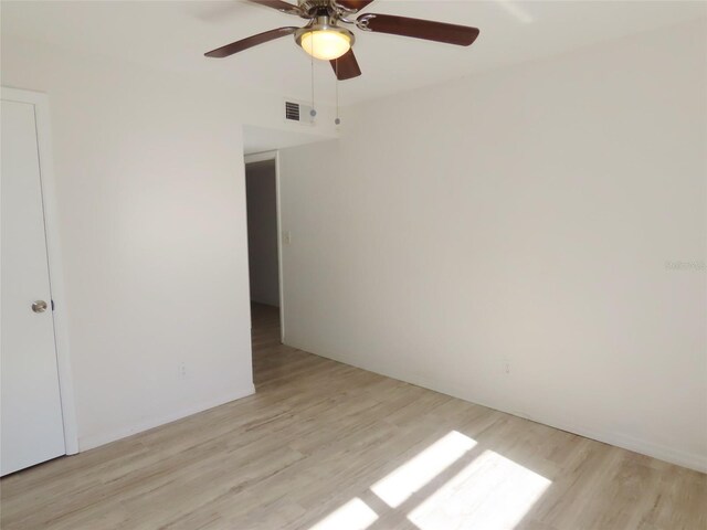 empty room with ceiling fan and light hardwood / wood-style flooring